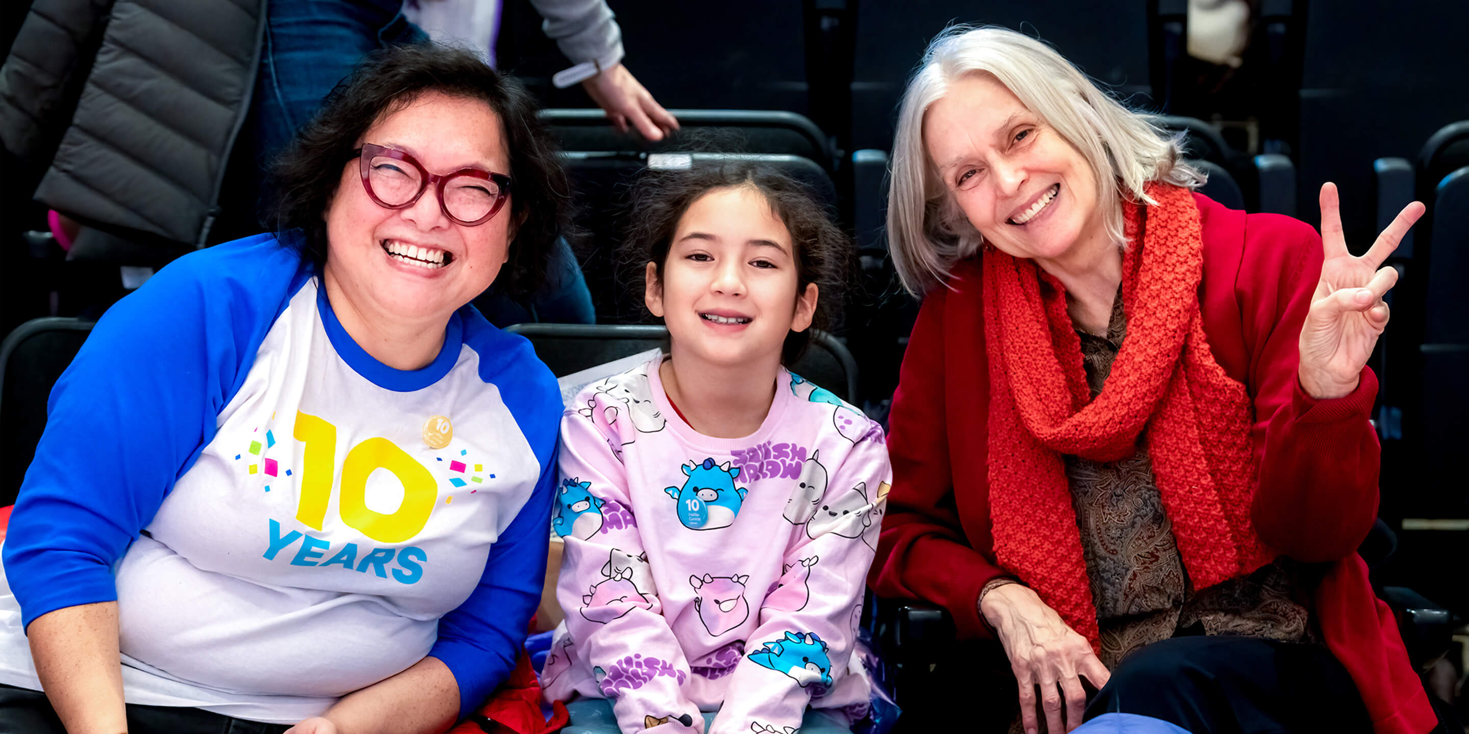 3 people posing for a photo sitting at the Paul O’Regan Hall during the anniversary celebration.